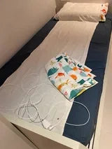 Erdungslaken und Kabel auf einem Bett